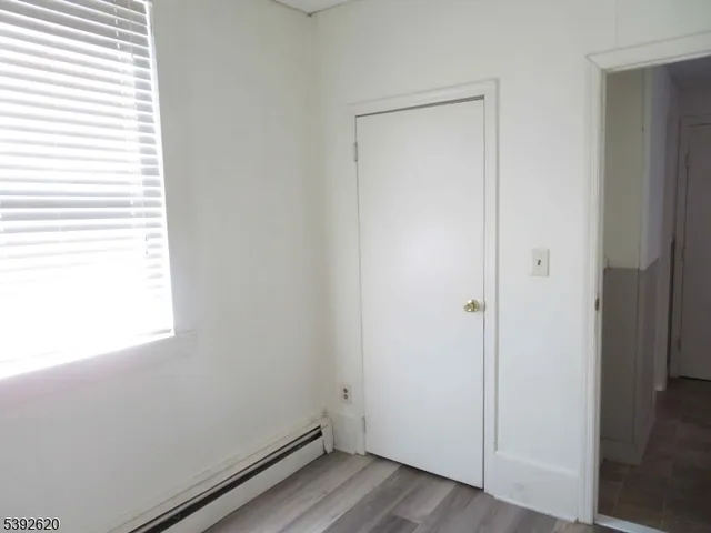 a view of small space with wooden floor and a window
