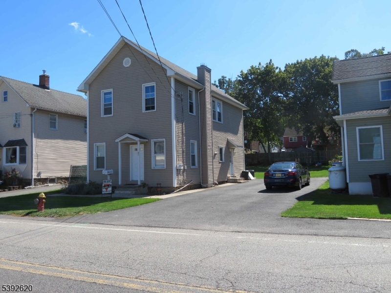 297 Center Street, Unit A Landing, NJ 07850 - Photo 2 of 18 a view of a brick house with a yard and large trees