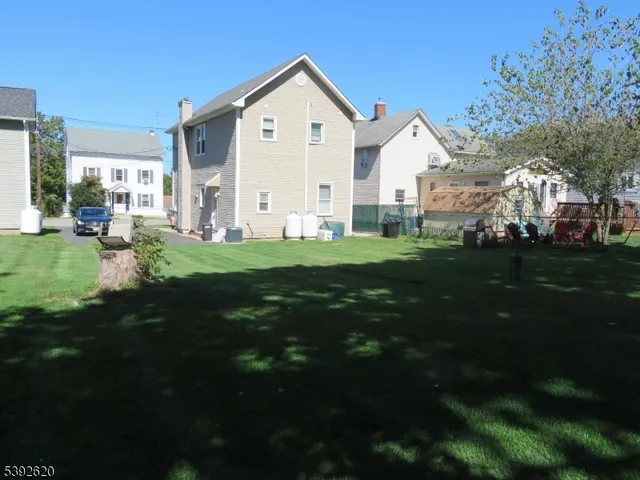 a view of a house with a big yard and large trees