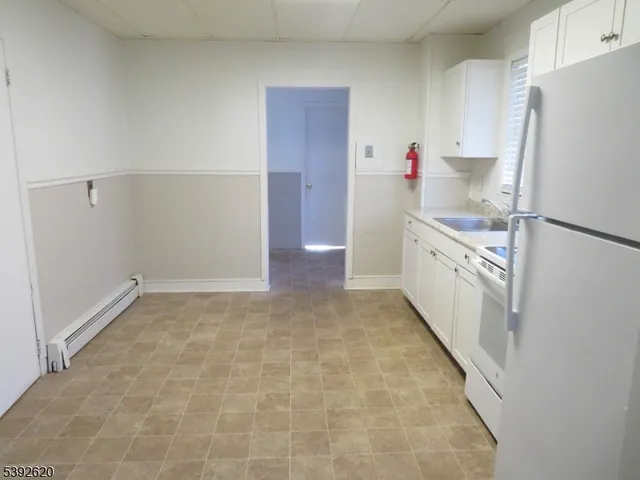 a kitchen with granite countertop a refrigerator and a sink