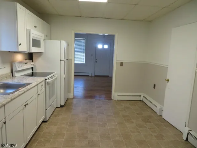 a view of a kitchen with white cabinets