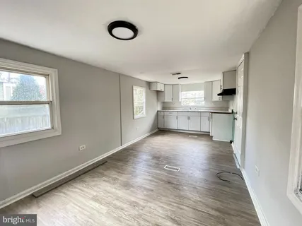 a large kitchen with cabinets and wooden floor