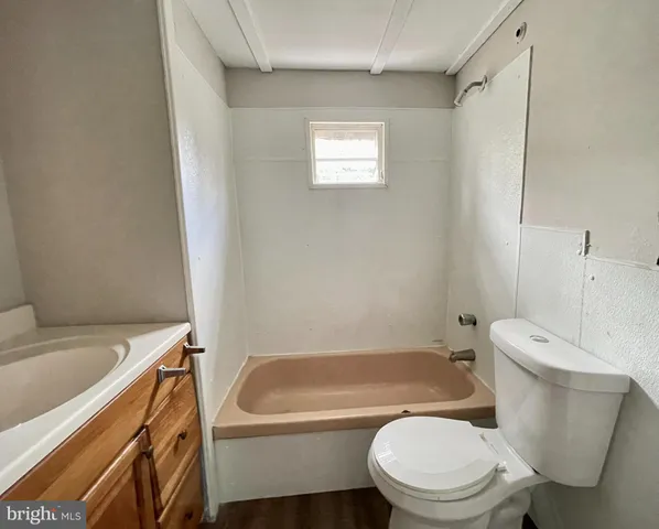 a white toilet sitting next to a bath tub