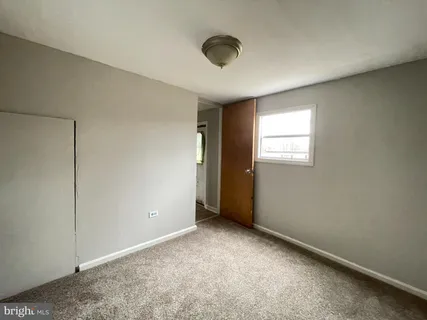 an empty room with windows and closet