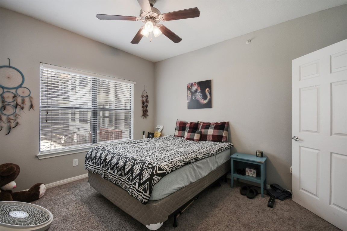 2502 Leon Street, Unit 313 Austin, TX 78705 - Photo 16 of 27 a bedroom with a bed and a chandelier