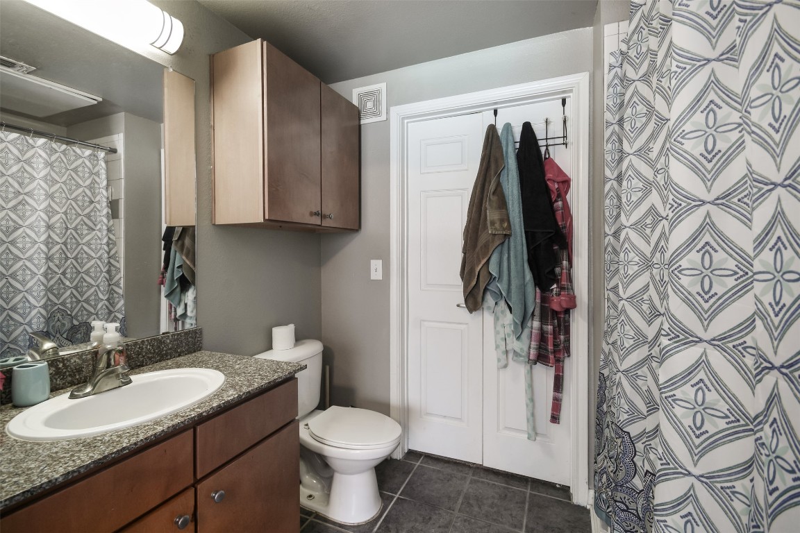 2502 Leon Street, Unit 313 Austin, TX 78705 - Photo 18 of 27 a bathroom with a granite countertop sink and a toilet