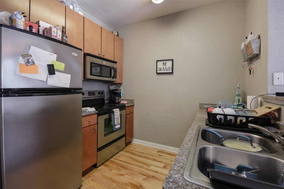 2502 Leon Street, Unit 313 Austin, TX 78705 - Photo 9 of 27 a kitchen with stainless steel appliances granite countertop a sink stove and cabinets