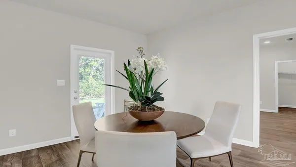a dining room with furniture and a potted plant