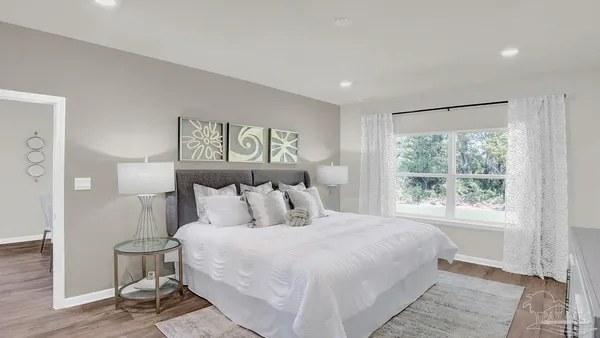 a bedroom with a bed and a painting on the wall