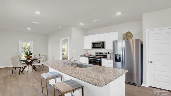 a large kitchen with a table and chairs