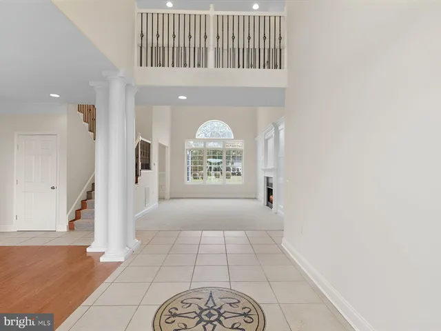 an empty room with wooden floor cabinet and windows