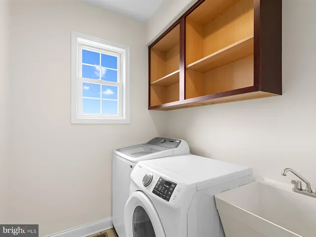 a front view of a house with a yard and potted plants