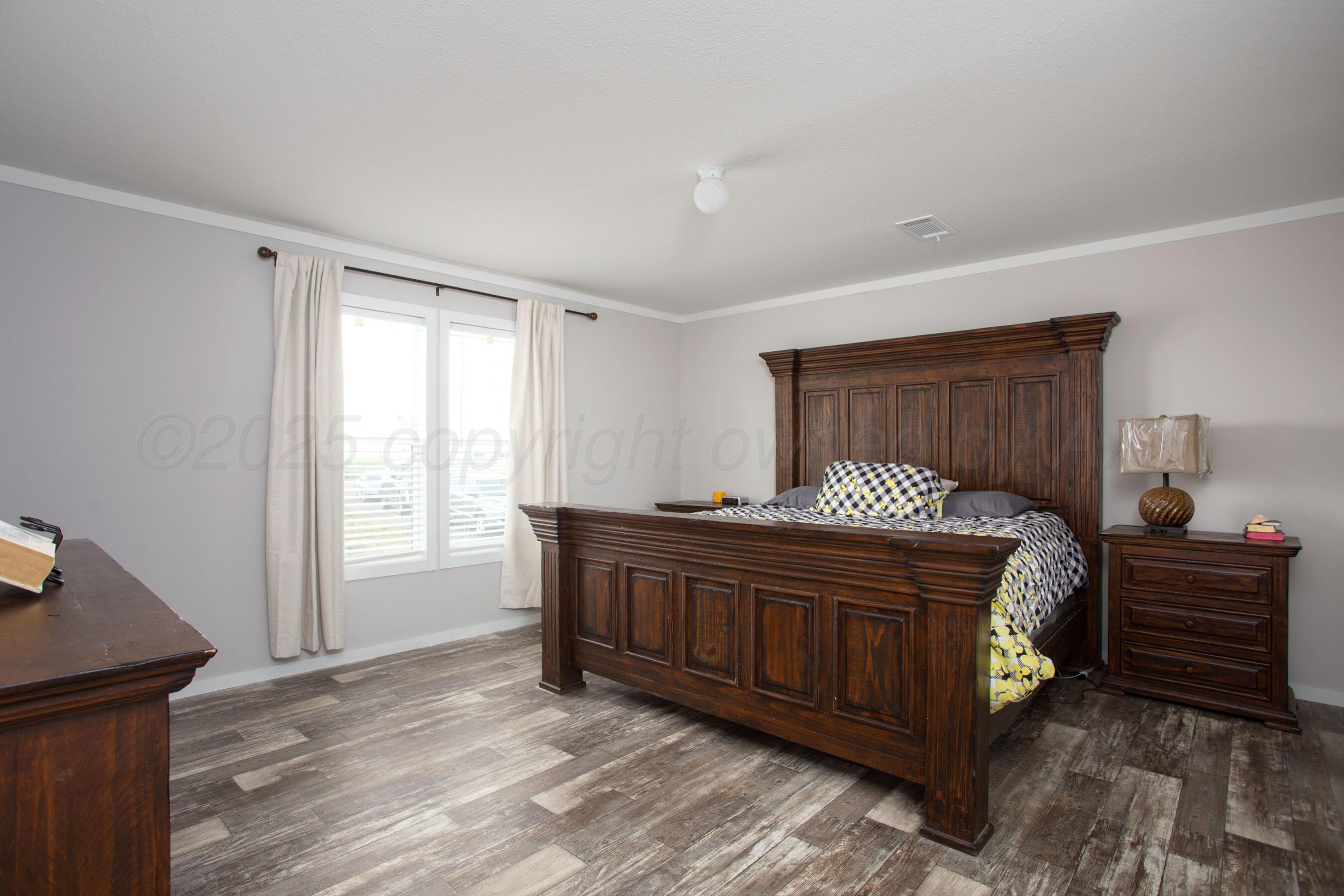 6300 Voorhees Road Amarillo, TX 79119 - Photo 13 of 27 a bedroom with a bed and wooden floor