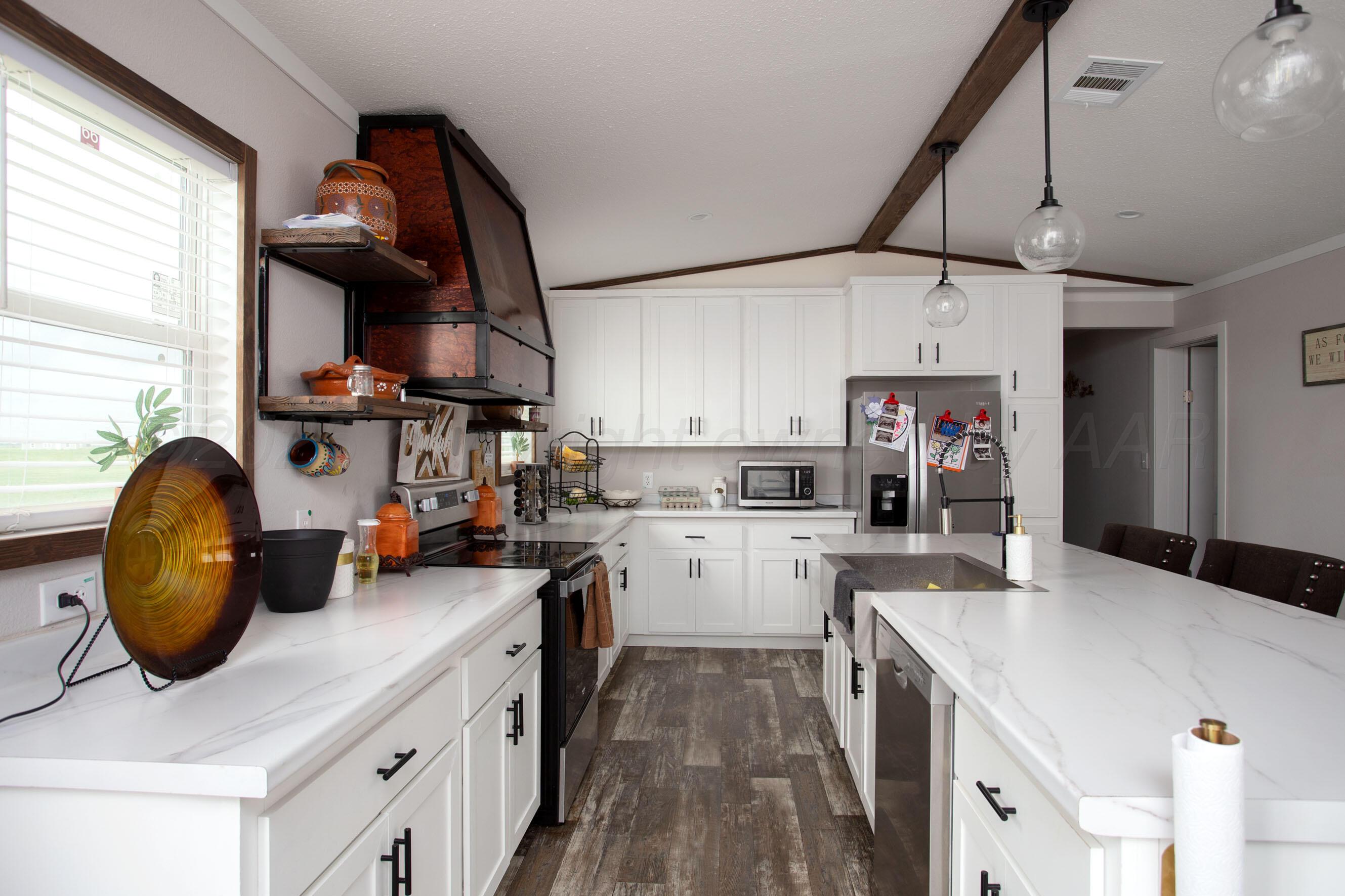 6300 Voorhees Road Amarillo, TX 79119 - Photo 8 of 27 a kitchen with a sink a stove and cabinets