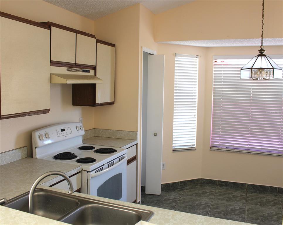 11100 Einbender Road Orlando, FL 32825 - Photo 7 of 26 a kitchen with stainless steel appliances granite countertop a sink and a stove