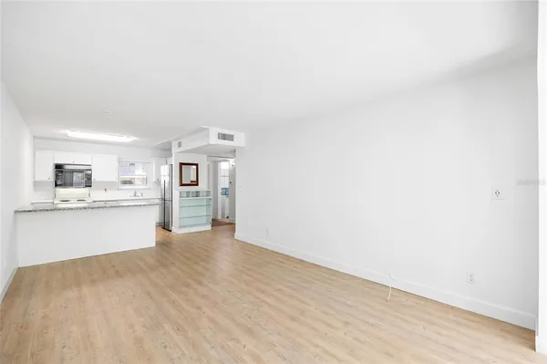 a view of a livingroom with wooden floor and furniture