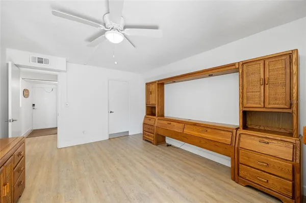 a view of a livingroom with furniture cabinet flat screen tv and wooden floor