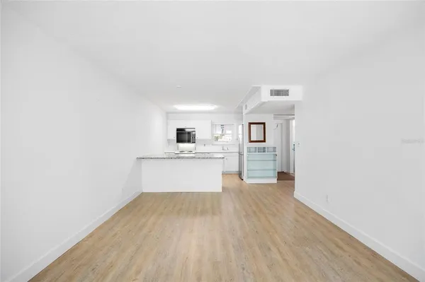 a view of a kitchen with sink a microwave and cabinets