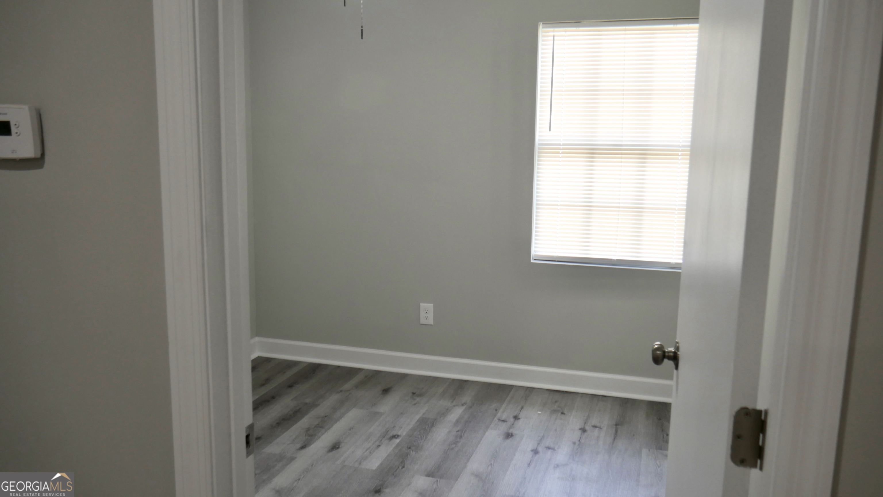 2830 North Lumpkin Road Columbus, GA 31903 - Photo 3 of 12 a view of an empty room with wooden floor and a window