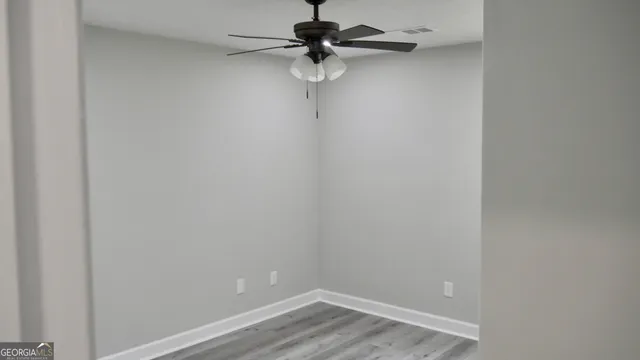 a view of a room with a fan and wooden floor
