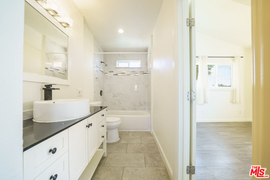 43609 Stanridge Avenue Lancaster, CA 93535 - Photo 13 of 25 a bathroom with a double vanity sink toilet mirror and bathtub