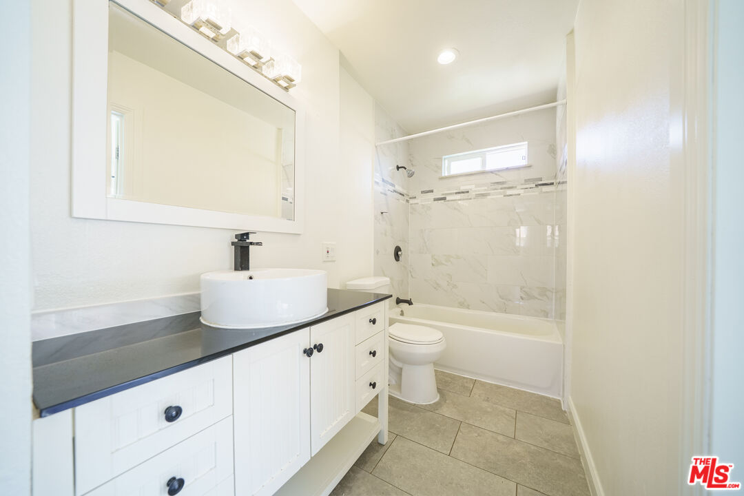 43609 Stanridge Avenue Lancaster, CA 93535 - Photo 14 of 25 a bathroom with a granite countertop sink toilet and shower
