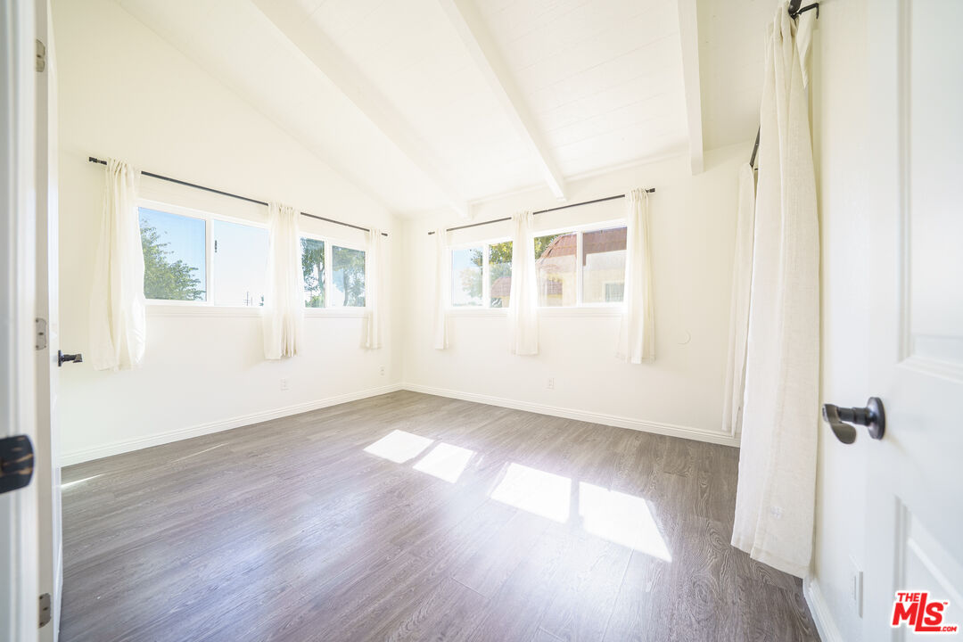 43609 Stanridge Avenue Lancaster, CA 93535 - Photo 16 of 25 an empty room with wooden floor and windows