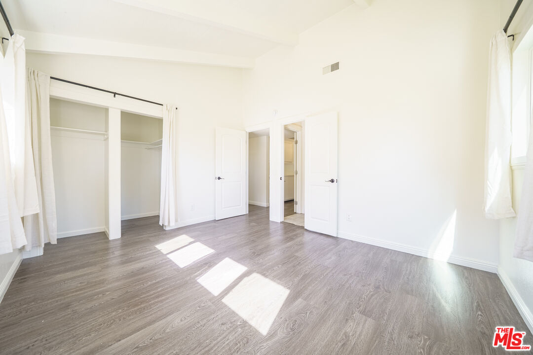 43609 Stanridge Avenue Lancaster, CA 93535 - Photo 18 of 25 an empty room with wooden floor and windows