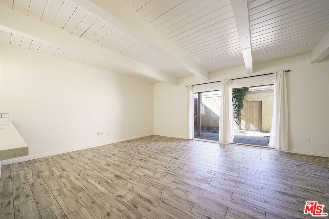 43609 Stanridge Avenue Lancaster, CA 93535 - Photo 2 of 25 a view of an empty room with wooden floor and a window