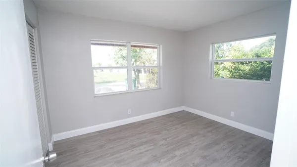 an empty room with wooden floor and white doors