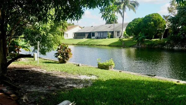 a view of a house with a yard and a pond