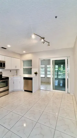 a large space with stainless steel appliances granite countertop a stove and cabinets