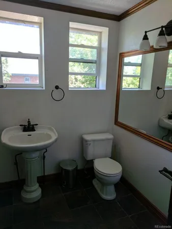 a bathroom with a toilet sink and mirror