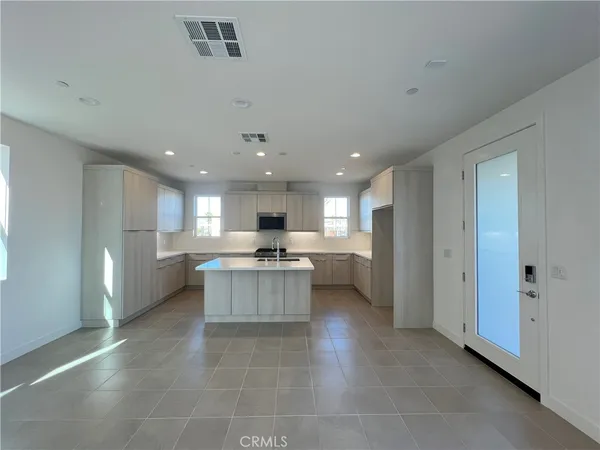 a large kitchen with a large counter top stainless steel appliances and cabinets