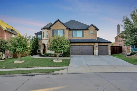 a front view of a house with a yard and trees