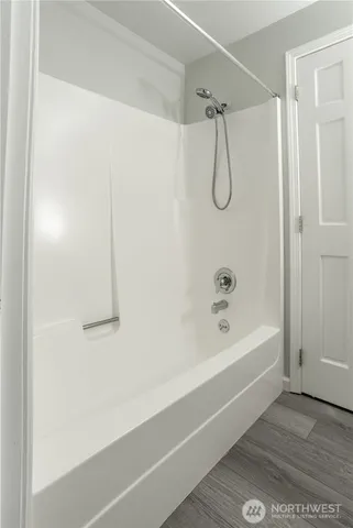 a bathroom with a bath tub with a shower