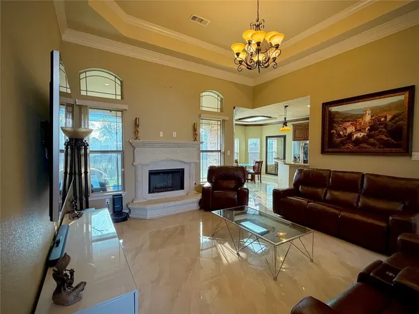 a living room with furniture a chandelier and a fireplace