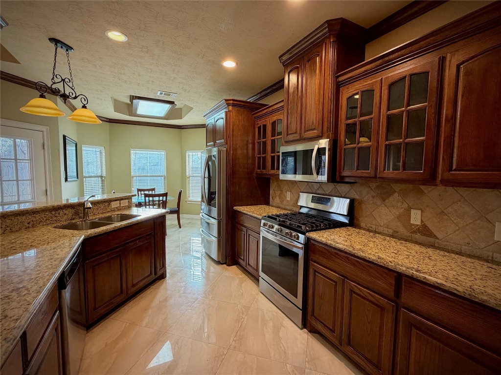 3741 Debbie Lane Groves, TX 77619 - Photo 4 of 16 a large kitchen with stainless steel appliances granite countertop a stove and a sink