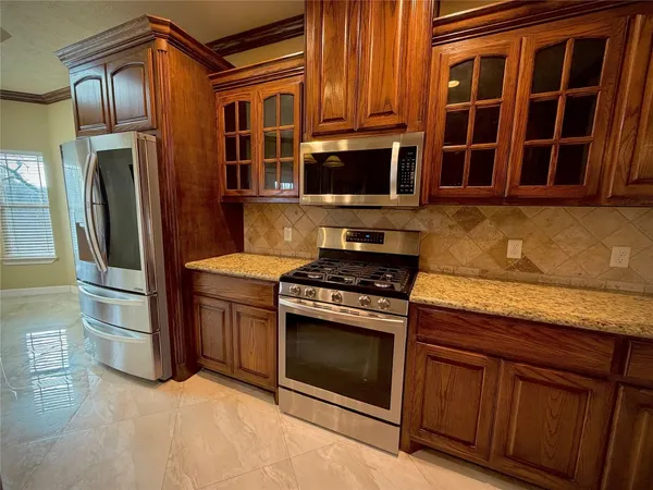 a kitchen with stainless steel appliances granite countertop a stove and a refrigerator