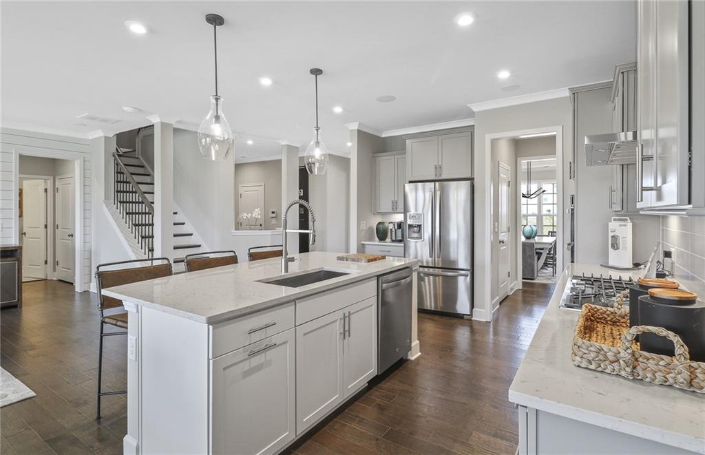 4397 Azalea Ridge Way Hoschton, GA 30548 - Photo 11 of 41 a kitchen with stainless steel appliances granite countertop a sink a stove and a refrigerator