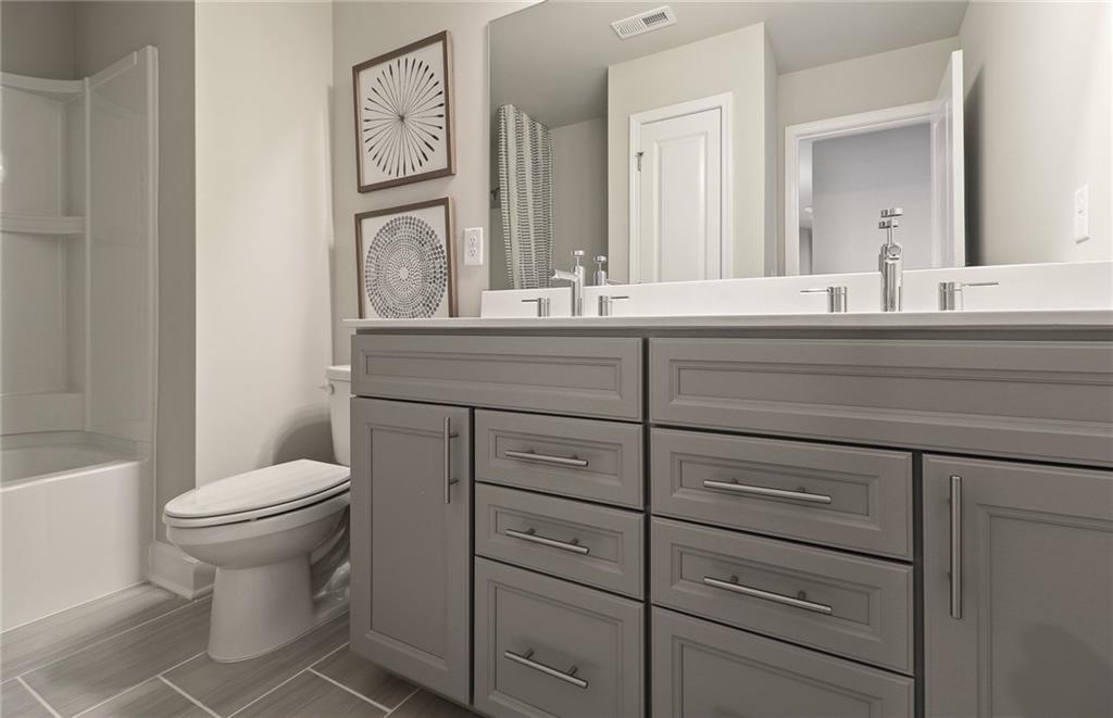 4397 Azalea Ridge Way Hoschton, GA 30548 - Photo 27 of 41 a bathroom with a toilet a sink and mirror