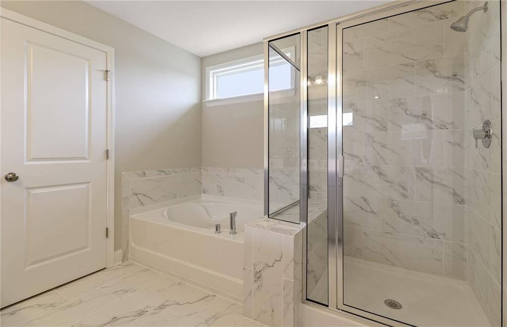 4397 Azalea Ridge Way Hoschton, GA 30548 - Photo 33 of 41 a bathroom with a bathtub and a shower