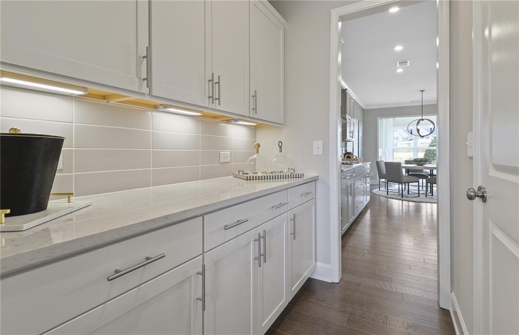 4397 Azalea Ridge Way Hoschton, GA 30548 - Photo 9 of 41 a hallway with white cabinets and wooden floor