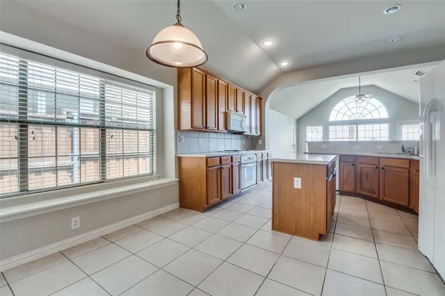 a open kitchen with cabinets a stove and a window