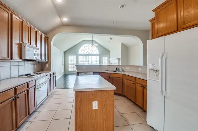 a kitchen with stainless steel appliances granite countertop a sink stove and cabinets
