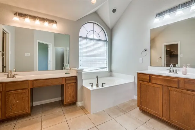 a spacious bathroom with a large tub sink and mirror