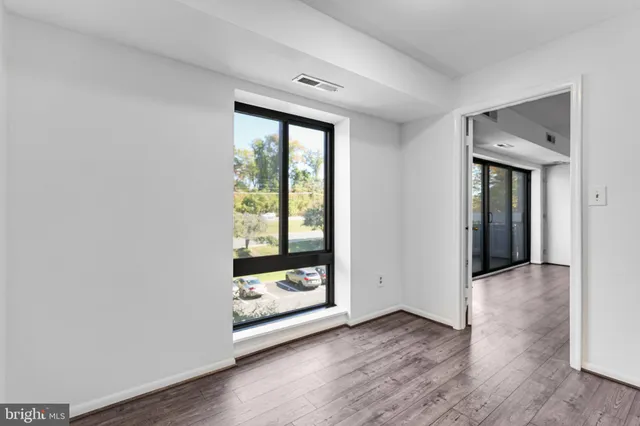 a view of a room with wooden floor and window