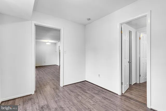 a view of an empty room with wooden floor & closet