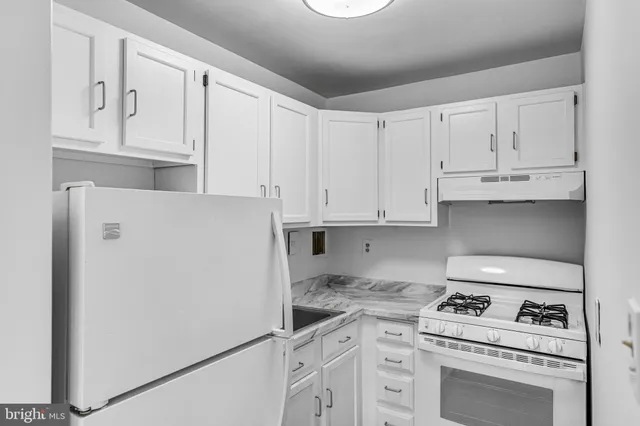 a kitchen with white cabinets and white appliances