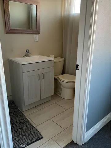 a bathroom with a sink a toilet and mirror